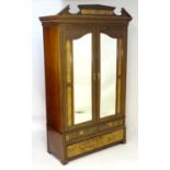 An early 20thC Art Nouveau style walnut wardrobe, with a moulded pediment above a dentil moulded