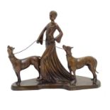 A 20thC bronze sculpture modelled as a lady walking two dogs. Approx. 17" high x 20" wide Please