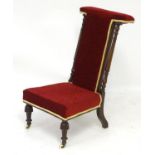 A late 19thC prie dieu with turned supports, burgundy upholstery with a cream trim and standing on