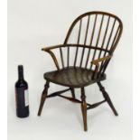 A mid 19thC childs Windsor chair with a double bow back above swept arms an elm seat and standing on