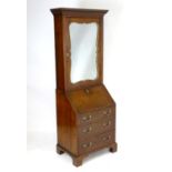 A Regency mahogany bureau bookcase with a moulded cornice above a dentil frieze and shaped