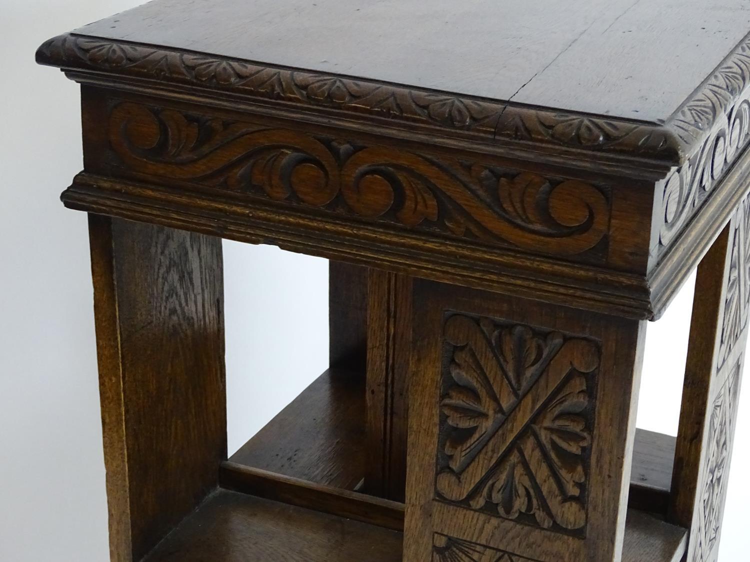 An early 20thC oak revolving bookcase with a moulded squared top above a lozenge carved floral frame - Bild 6 aus 7