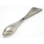 A silver handled shoe horn, the handle with foliate decoration. Hallmarked Birmingham 1915 maker
