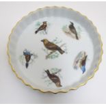 A French L Lourioux Le Faune pie dish with fluted sides and gilt rim, decorated with six birds to