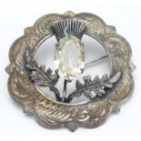 A Victorian Scottish silver brooch with engraved decoration and central thistle motif Hallmarked