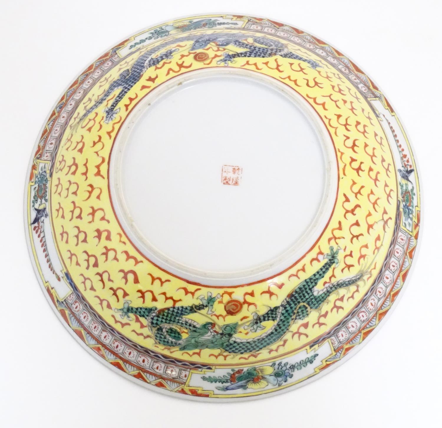 A Chinese famille jeune bowl decorated with two dragons and patterned border. Character marks under. - Image 4 of 7