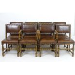 A set of eight mid 20thC dining chairs with leather and brass studded upholstery, standing on