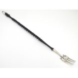 A silver toasting fork with turned ebonised handle. The silver fork section hallmarked Chester