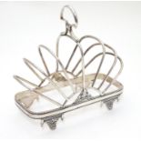 A silver plate 7 bar toast / letter rack with loop handle. Indistinctly marked with registration