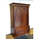 A 19thC mahogany press with a moulded cornice above two large doors with lancet shaped panelling,