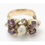 A 9ct gold ring dress ring set with 4 amethysts and two pearls. Hallmarked to outer band London 1976