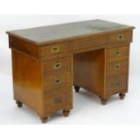 An early / mid 19thC mahogany double pedestal campaign desk with an inset leather top above a single