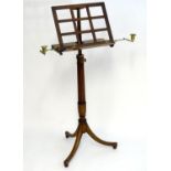 A Regency mahogany adjustable music stand with a latticework style slope, two brass candelabra and