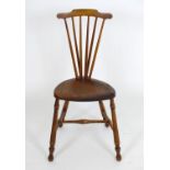 An early 20thC Windsor chair with a comb back and an elm saddle seat, that chair raised on turned