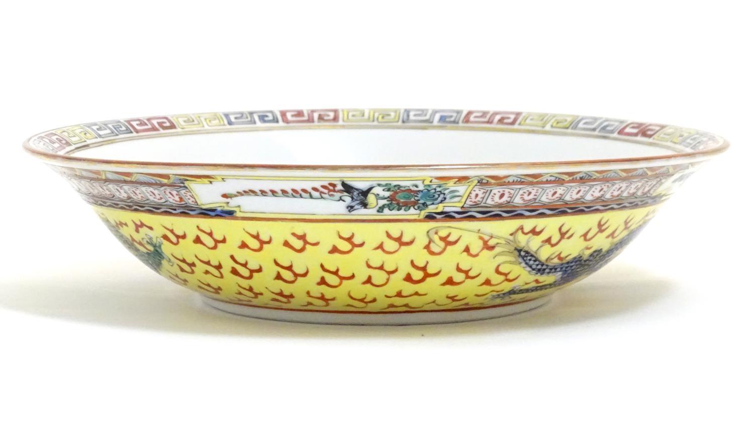 A Chinese famille jeune bowl decorated with two dragons and patterned border. Character marks under. - Image 3 of 7