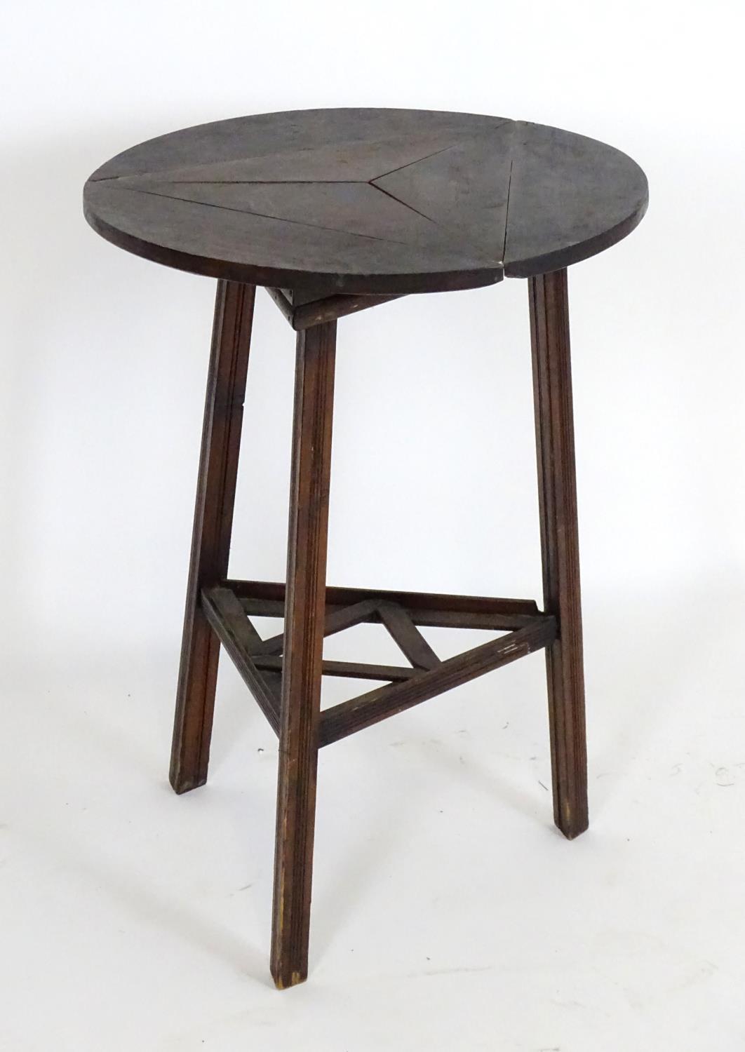 An early 20thC country made cricket table with a folding rotating top and raised on three squared - Bild 4 aus 5