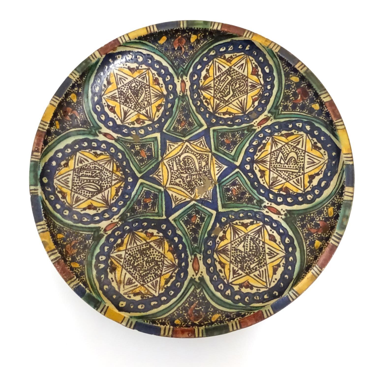 A Moroccan charger with geometric designs, vignettes with six point star detail and Islamic