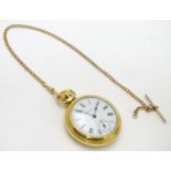 An Ingersoll gold plated open faced pocket watch on gold plated watch chain. White enamel dial