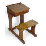 An early 20thC school desk and seat with a liftable slope, the slope having painted alphabet