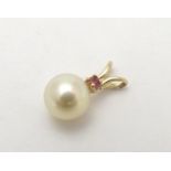 A 9ct gold pendant set with pearl and red spinel. Approx 1 /4" long Please Note - we do not make