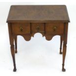 A George I style walnut lowboy with a rectangular feather banded top above three short drawers