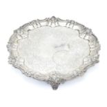 A Victorian silver salver with engraved decoration and on three scrolled feet. Hallmarked London