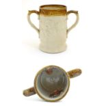 A 19thC two tone stoneware loving cup tankard, the body moulded in relief with tavern scenes with