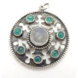 An Arts & Crafts white metal pendant set with central moonstone cabochon bordered by green stone