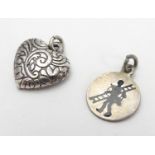Two pendant charms, one f heart form, the other circular with silhouette decoration. Each approx.
