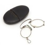 19thC folding pince-nez glasses contained within an oval papier mache case with inlaid detail.