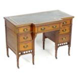 An early 20thC writing table with a gold tooled leather top above a central drawer flanked by two