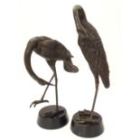 A 20thC cast bronze modelled as a crane bird, mounted on a circular wooden base. Together with