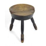 An 18thC country made elm stool, with a circular seat and three turned tapering legs. 11" in