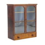 A late 19thC / early 20thC bookcase with two glazed doors above a single long drawer with turned