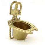 A 19thC brass smoker's companion, comprising ashtray and vesta holder with cast horse shoe and