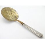 A French silver handled serving spoon with foliate decoration to the handle and a scallop formed