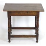 An early 20thC oak side table with a proud top above a single short drawer, the table raised on