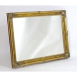 A 20thC mirror with a gilt frame, moulded surround and beaded decoration. 42" wide x 30" high.