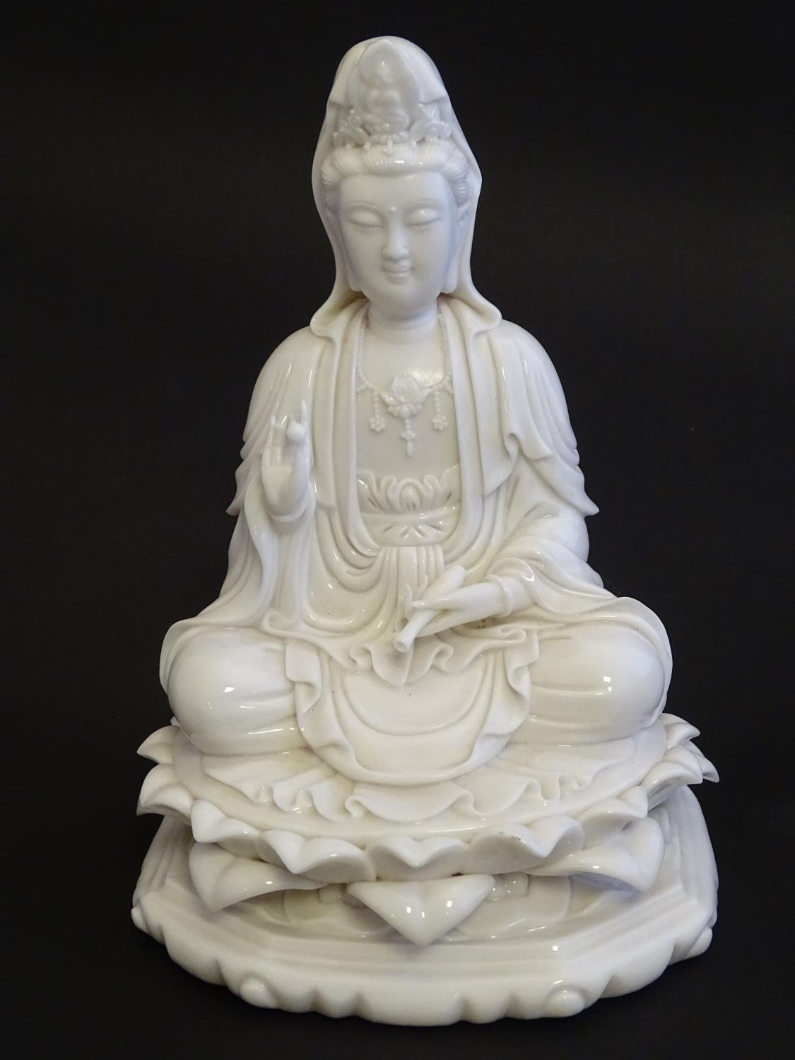 A Chinese blanc de chine figure depicting Guanyin seated on a lotus flower base. Approx. 7 1/2" high