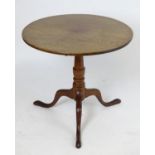 A 19thC oak tripod table with a circular tilt top above a turned stem and three cabriole legs