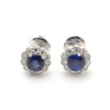 A pair of 18ct gold stud earrings set with central sapphire bordered by diamonds. Approx. 1/4"