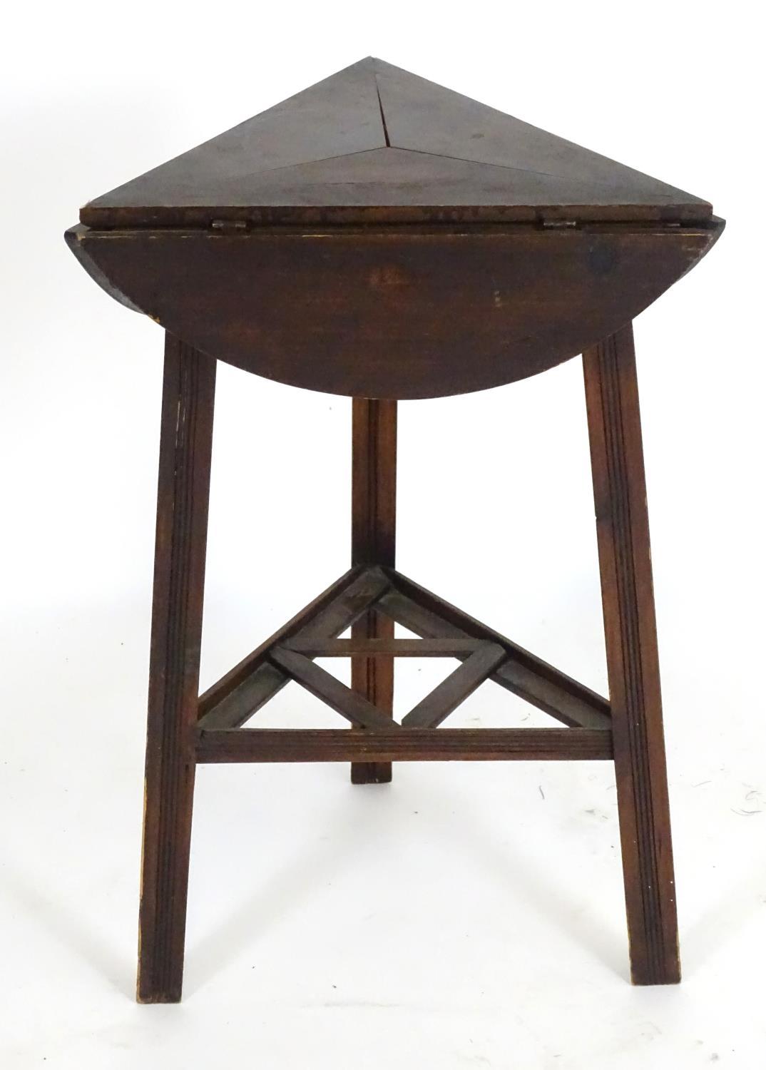 An early 20thC country made cricket table with a folding rotating top and raised on three squared - Bild 2 aus 5
