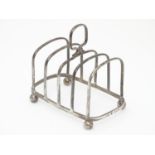 A Silver four division toast rack raised on four bun feet. Hallmarked Birmingham 1923 maker