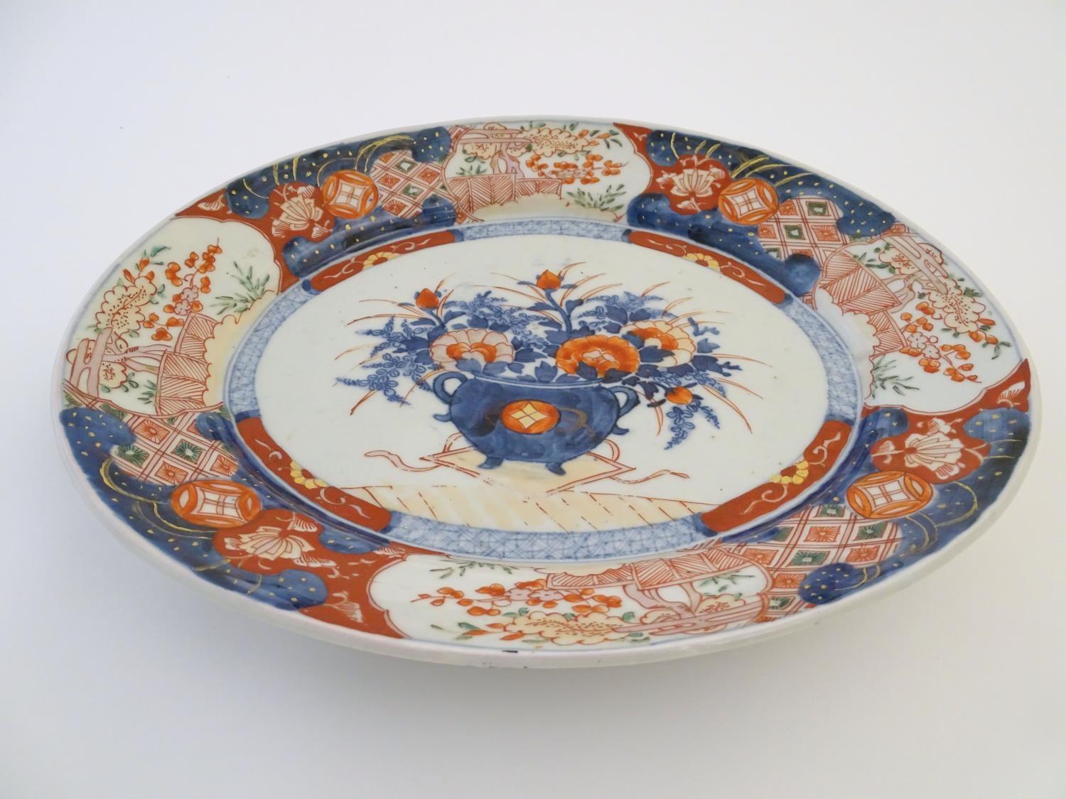 A Japanese Imari style plate, the centre decorated with a vase of flowers with a floral border. - Image 3 of 6