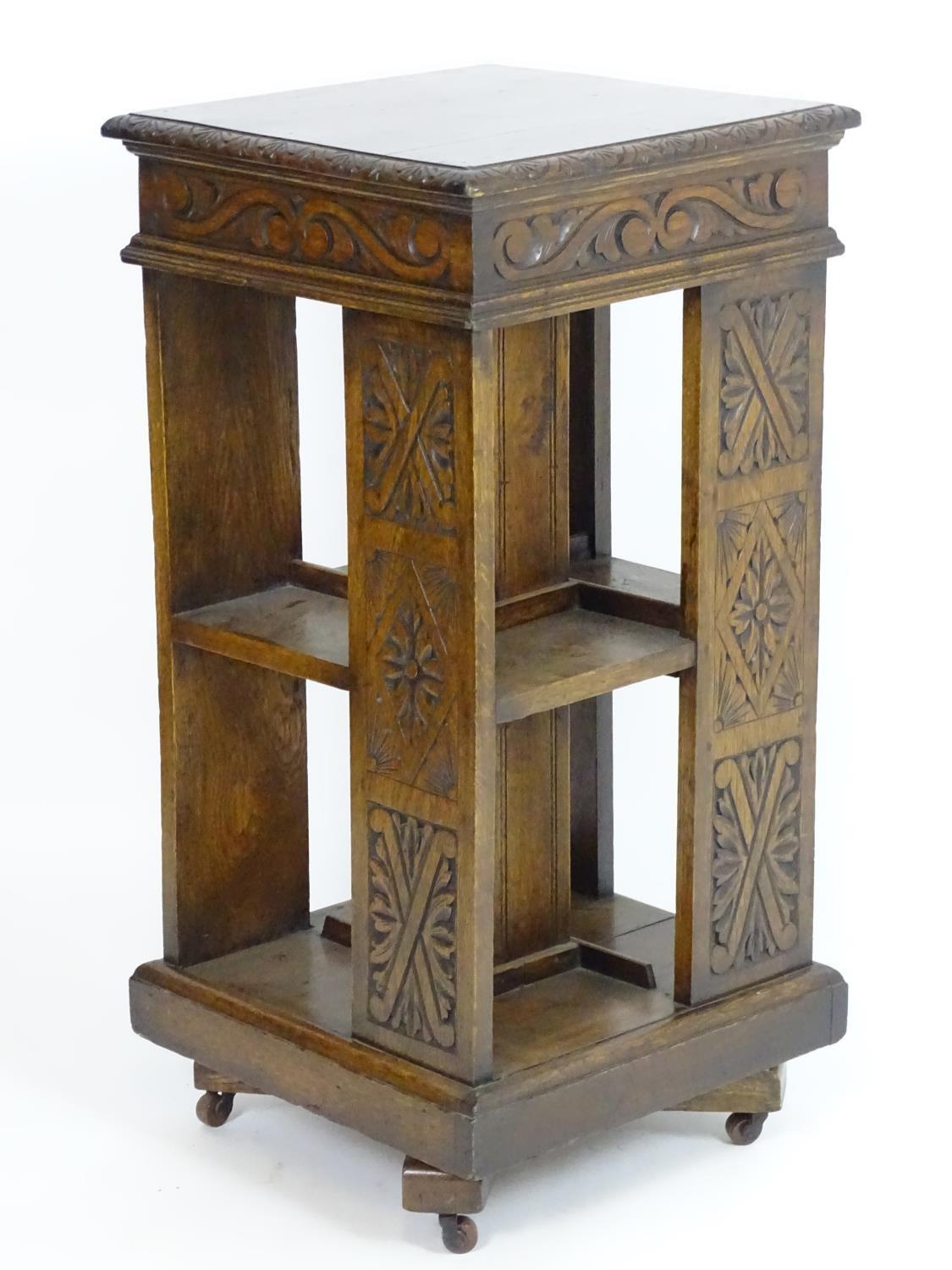 An early 20thC oak revolving bookcase with a moulded squared top above a lozenge carved floral frame - Bild 4 aus 7