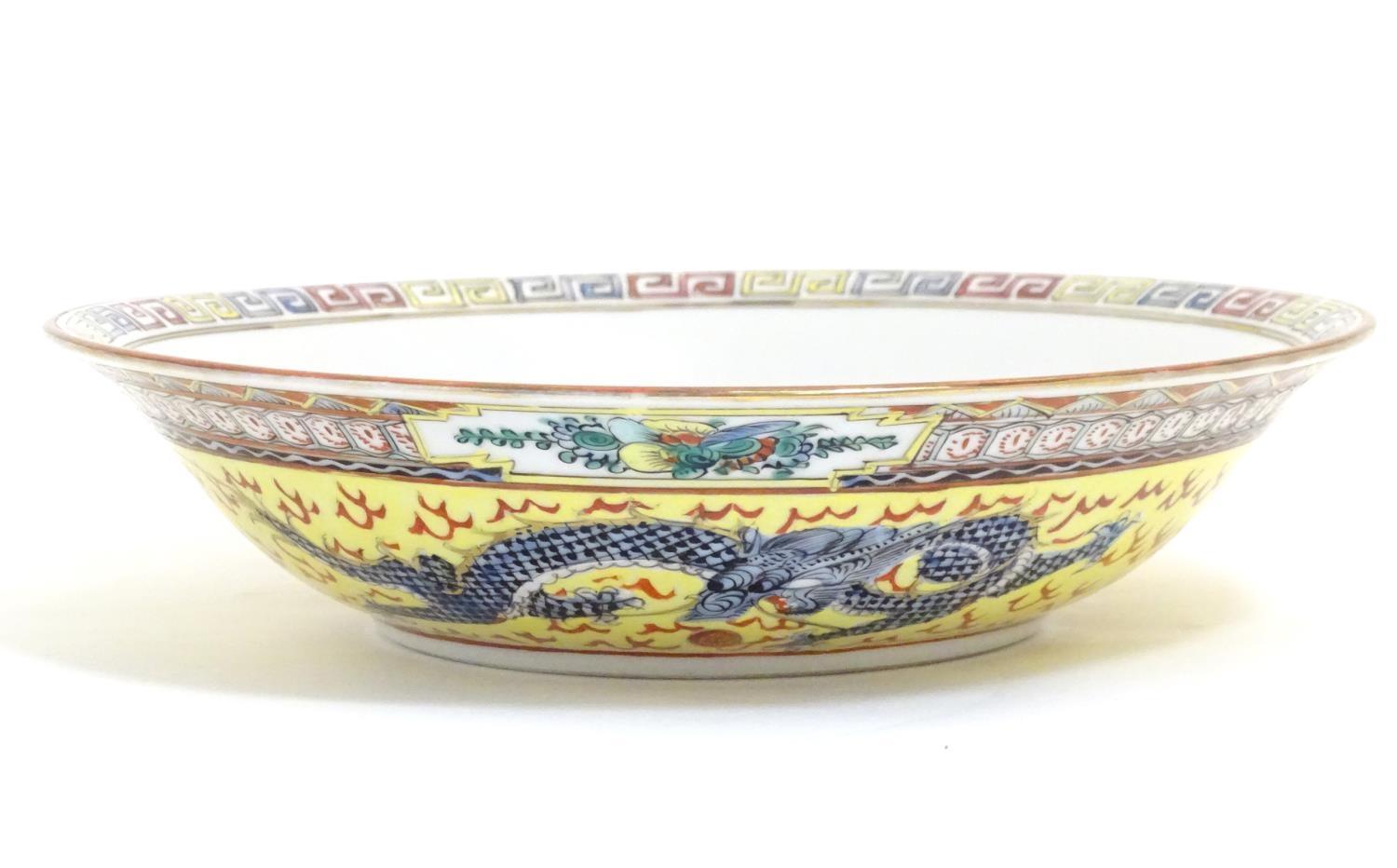 A Chinese famille jeune bowl decorated with two dragons and patterned border. Character marks under. - Image 2 of 7