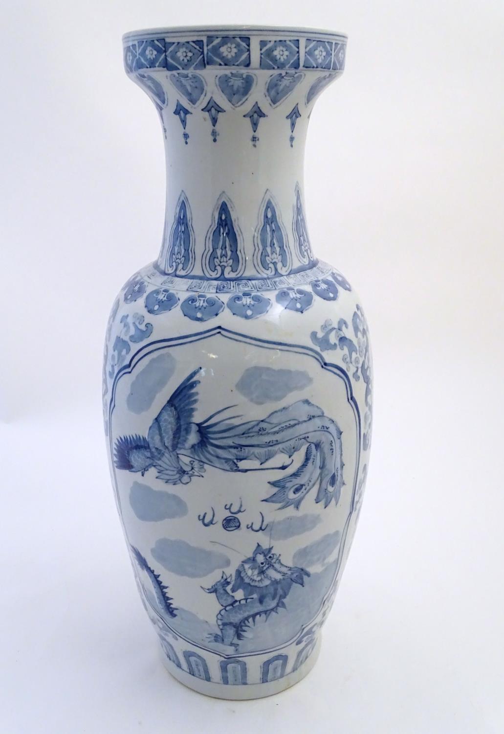 A large Chinese blue and white vase decorated with flowers, foliage and a stylised phoenix and