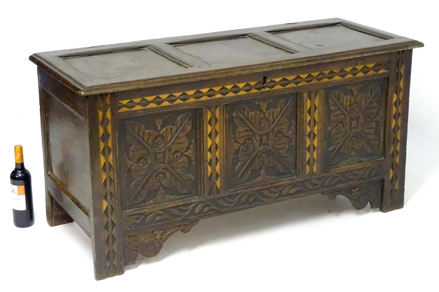 A 17thC oak three panel coffer with a moulded lid above carved panelling to the front with floral - Bild 3 aus 11