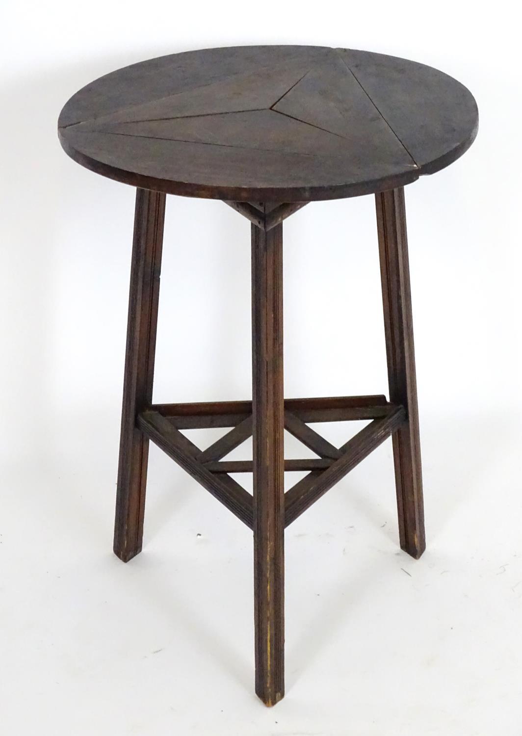 An early 20thC country made cricket table with a folding rotating top and raised on three squared - Bild 3 aus 5