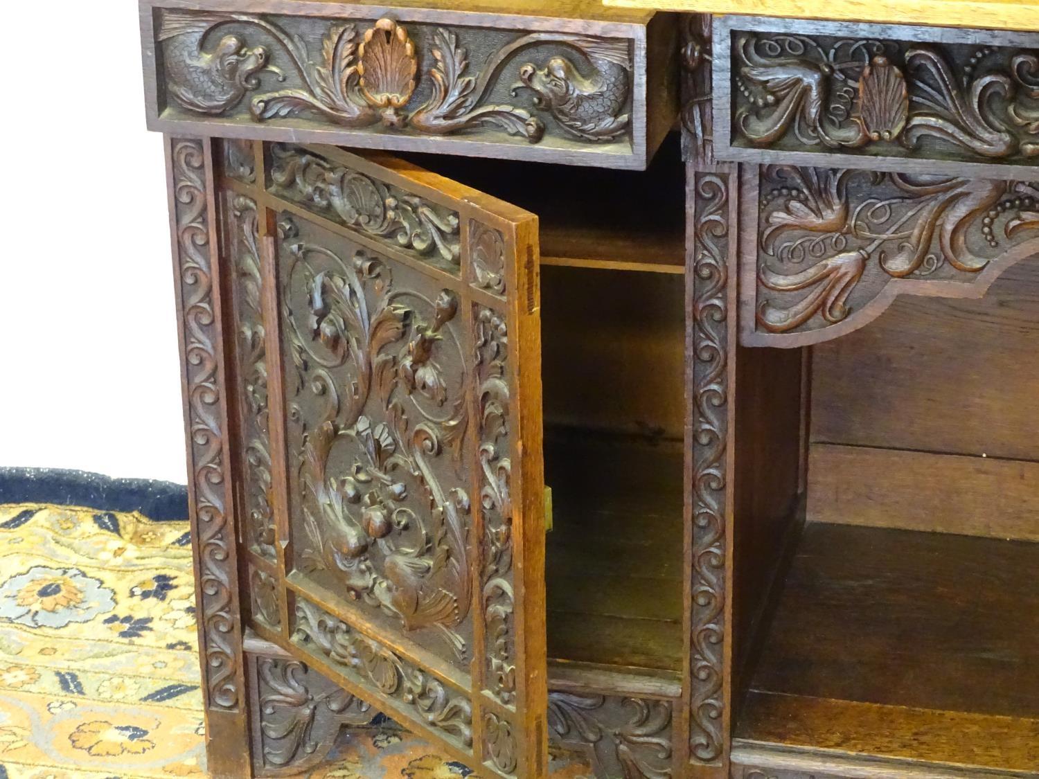 An early 20thC dresser with a blind fretwork carved plate rack above a carved slope and three - Bild 2 aus 5